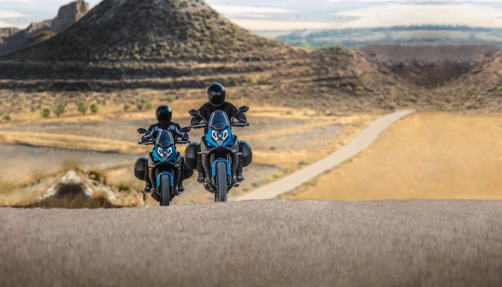 Actiefoto van twee motorrijders op een CF Moto 650 MT waarvan beide met koffers uitgerust in woestijnachtige landschap.