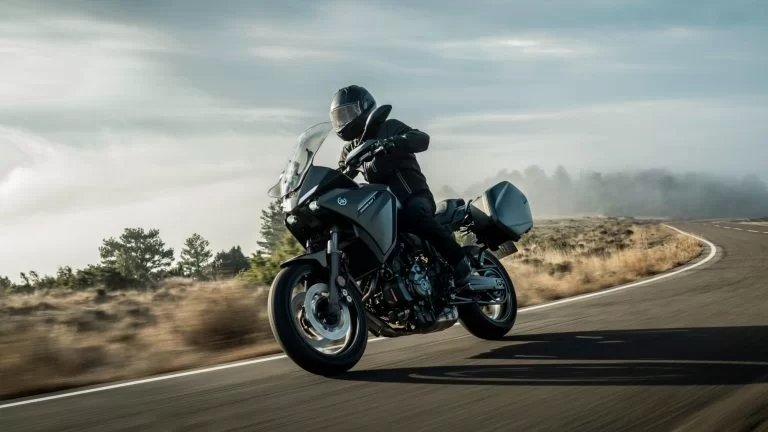 Actiefoto 2022-Yamaha-MT07TRGT-EU-Tech_Kamo-Action met motorrijder in een mistig natuurgebied op een bochtige weg rijdt
