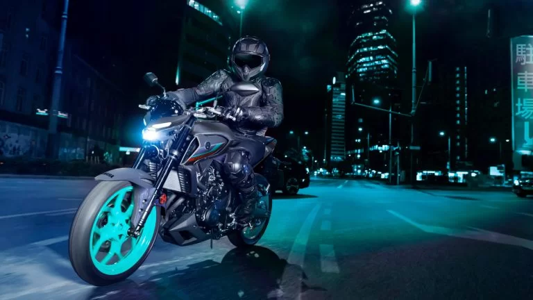 Actiefoto 2022-Yamaha-MT320-EU-Cyan_Storm-Action-009-03 vooraanzicht van motorrijder die in de nacht door de stad rijdt