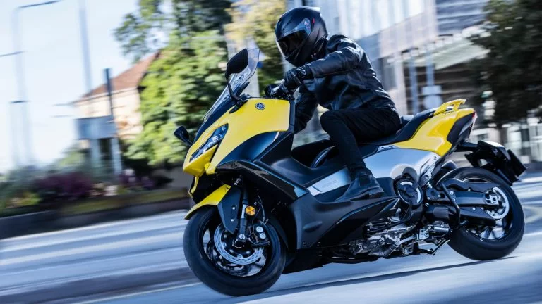 Actiefoto 2022-Yamaha-XP500A-EU-Extreme_Yellow-Action-003 met motorrijder die een bocht neemt.