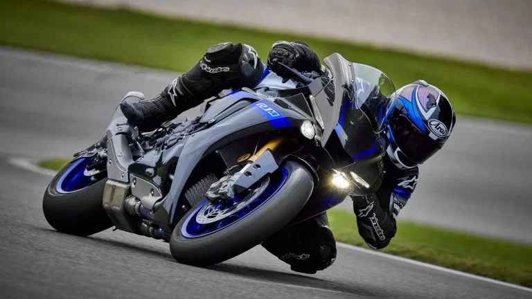 Zwart met blauwe Yamaha YZF-R1M rijd door de bocht van een race circuit