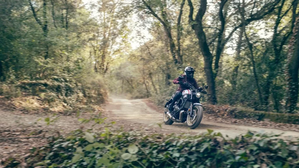motorrijder rijdt op een sport Heritage motor over een bospad