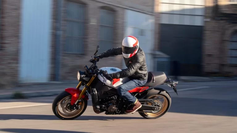 Motorrijder neemt een scherpe bocht op een sport Heritage motor met gebouwen op de achtergrond