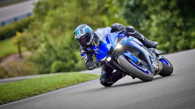 Motorrijder op een blauwe supersport motor rijdt over het circuit door een bocht