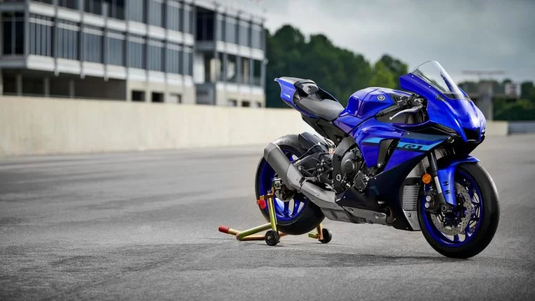 Blauwe supersport motor staat op de paddockstand op het circuit
