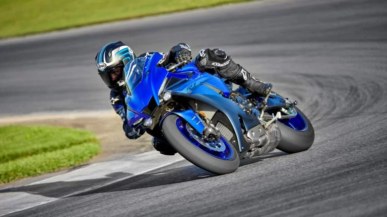 Motorrijder op een blauwe supersport motor rijdt over het circuit
