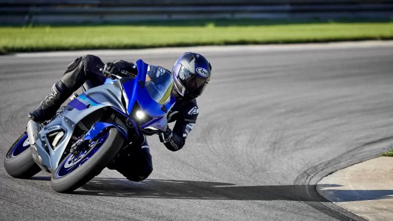 Motorrijder rijdt op een blauwe supersport motor door een bocht
