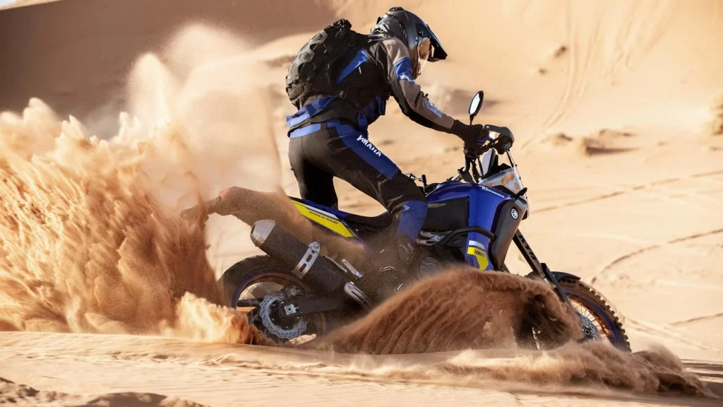 adventure motor met motorrijder die zijn weg baant door het zand met de motor in de woestijn