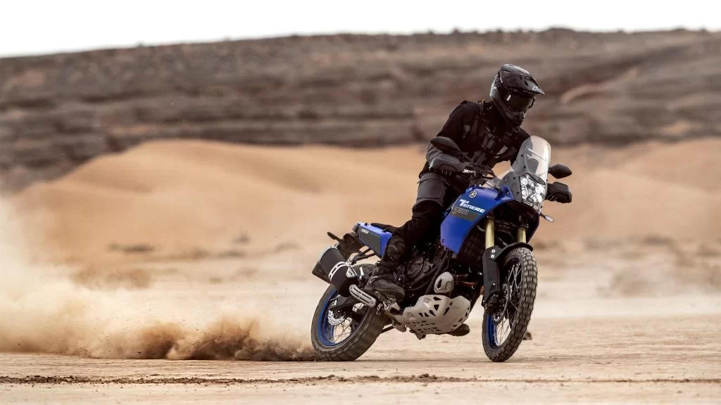 Motorrijder rijdt op een blauwe adventure motor door de woestijn