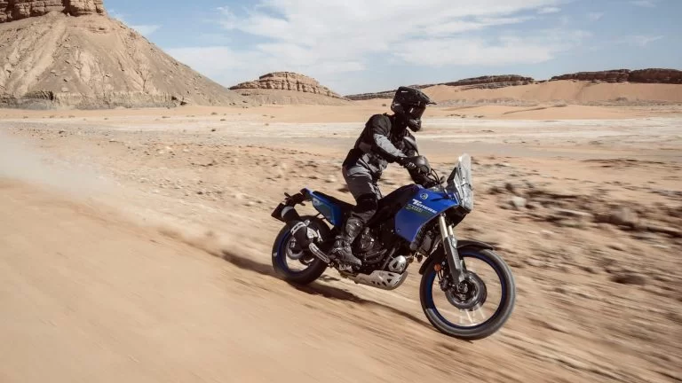 motorrijder rijdt op een blauwe adventure motor door de woestijn