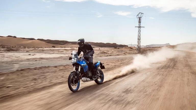 motorrijder rijdt op een adventure motor over een zanderig woestijn pad