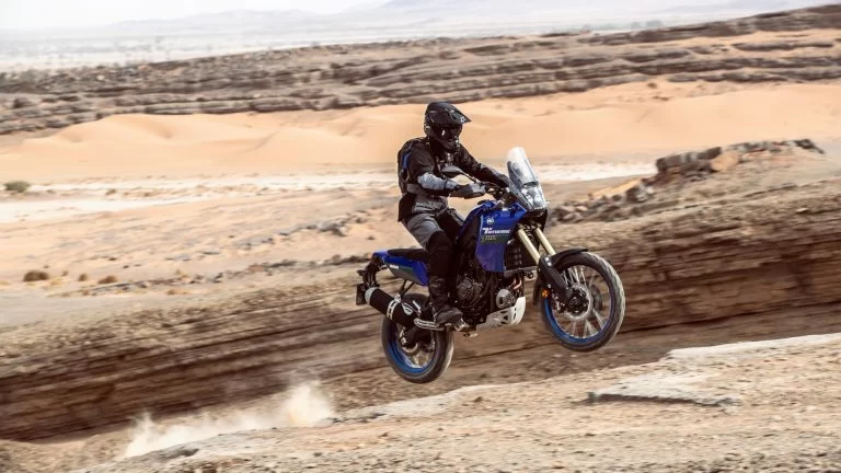 Motorrijder komt los van de grond met een adventure motor in de woestijn