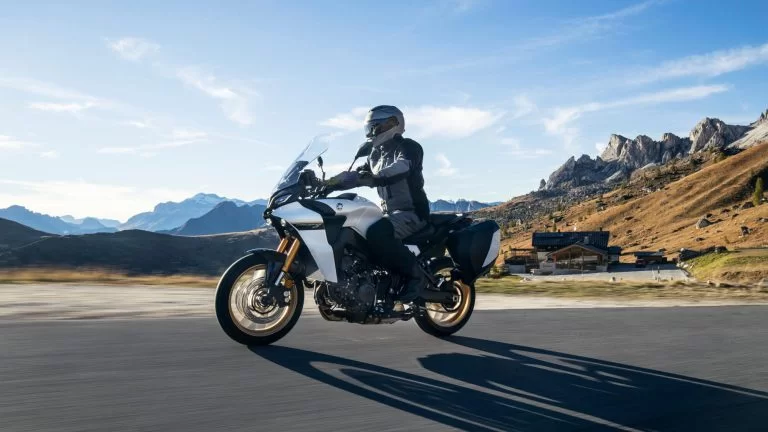 Motorrijder rijdt op een sport tour motor met bergen op de achtergrond