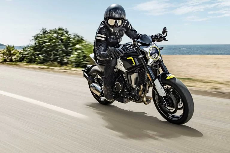Actie CF Moto 700CL-X SPORT parelwit met motorrijder op een weg met hoge snelheid