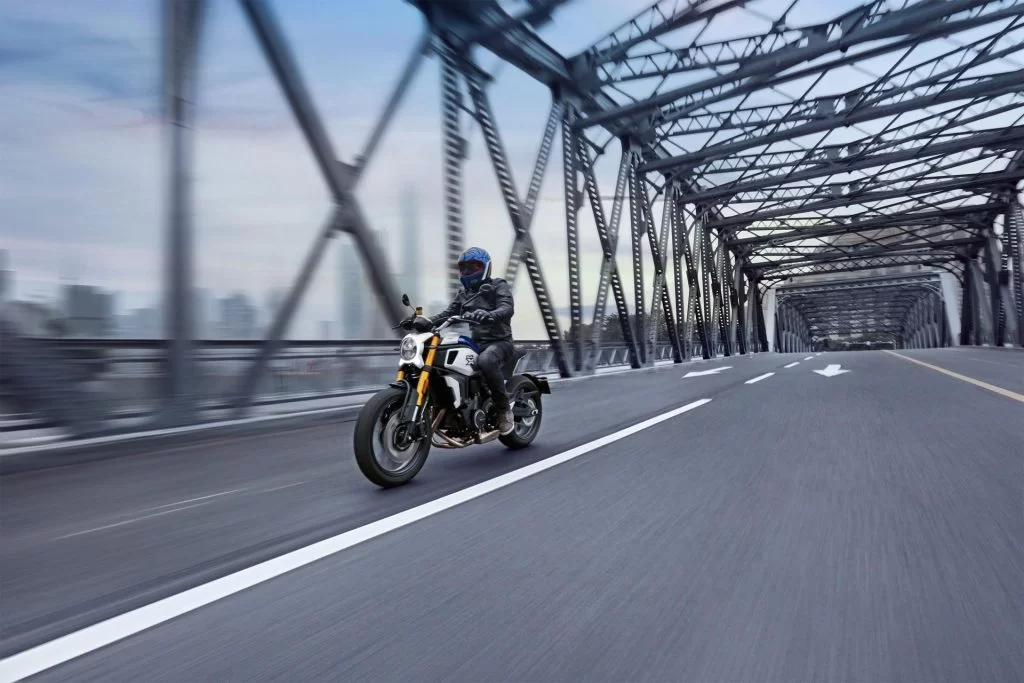 Actiefoto CF Moto 700CL-X Heritage met motorrijder op een brug