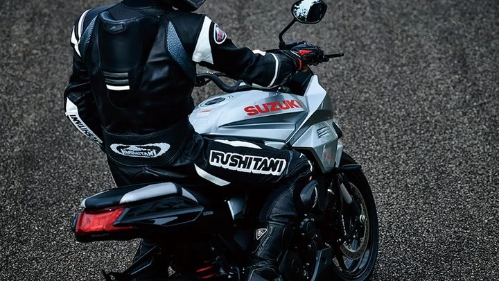 Lifestylefoto 2023 Suzuki Katana van motorrijder met motorfiets van bovenaf genomen.