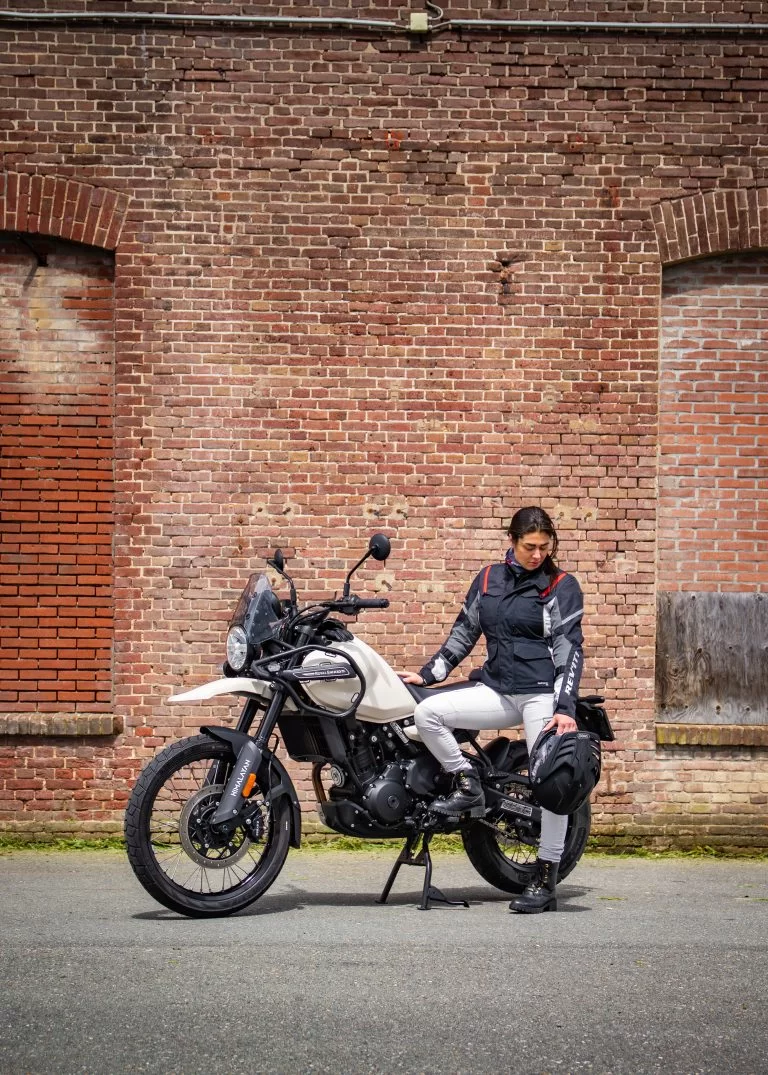 Royal Enfield Himalayan met rijder voor een pand.