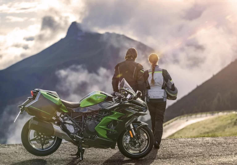 Lifestylefoto Ninja H2 SX van motorrijder met passagier die naar bergketen kijken met motor op de voorgrond