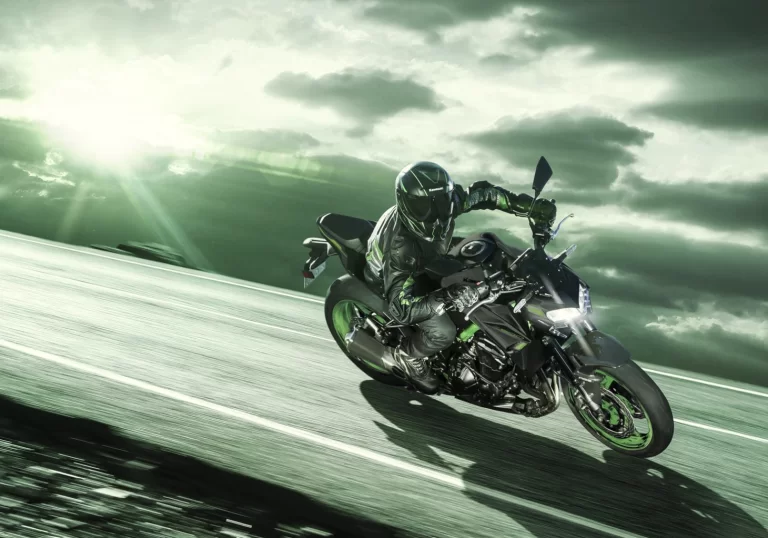 Actiefoto 2023 Kawasaki Z900 met motorrijder die hangend de bocht in rijdt.