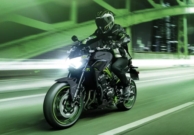 Actiefoto 2023 Kawasaki Z900 met motorrijder die in de avond met hoge snelheid over een brug rijdt