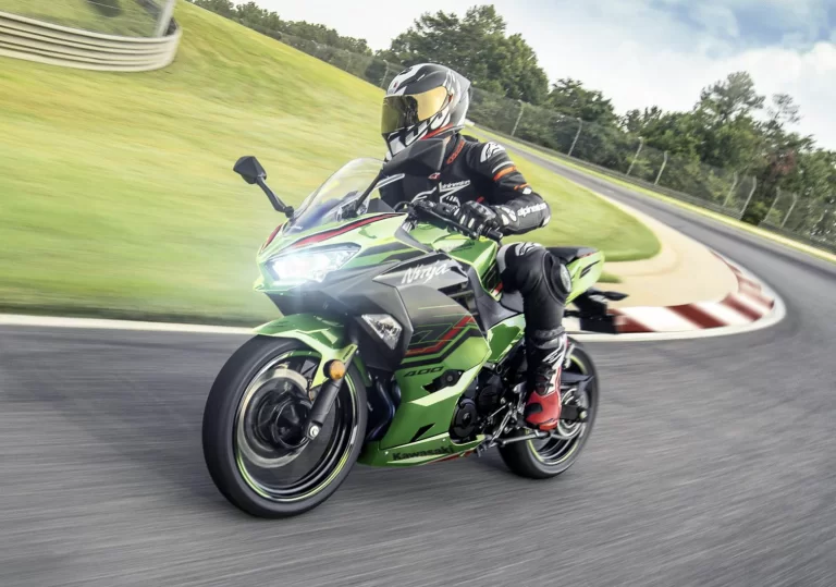 Actiefoto 2023 Kawasaki Ninja 400 met motorrijder op racecircuit hangend in de bocht