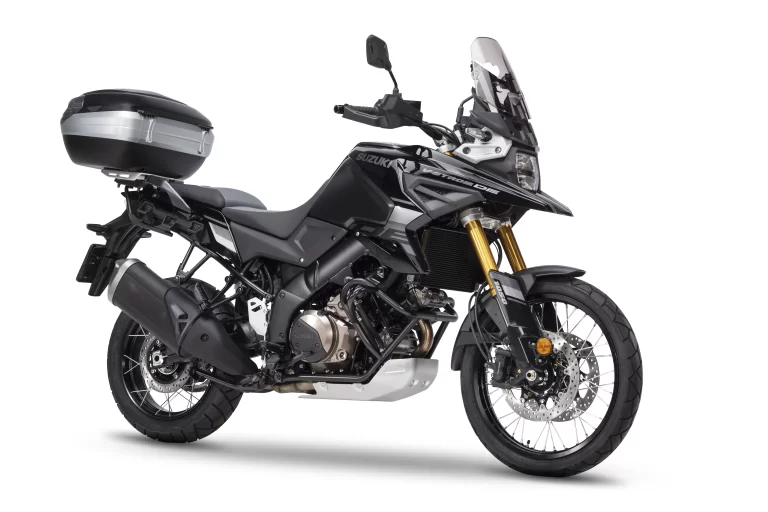 Suzuki motor met touring pack accessoires in een witte studio.