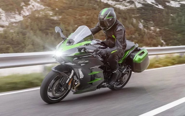 Kawasaki sport tour motor op de weg met bergen op de achtergrond