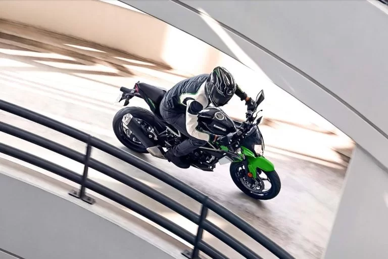 Kawasaki motor rijdend langs hek
