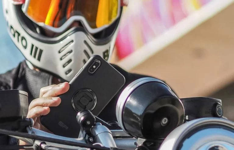 close up van motorrijder die op smartphone kijkt